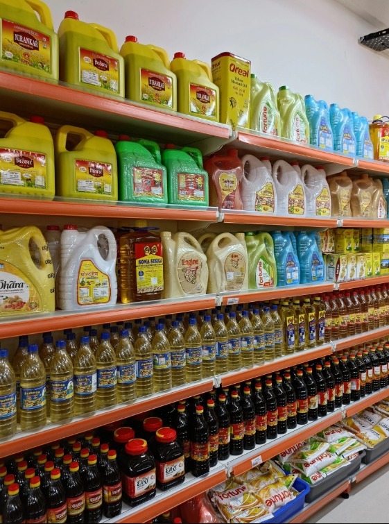 Refined cooking oils, pure mustard oil bottles, and pure ghee tins arranged neatly on supermarket shelves